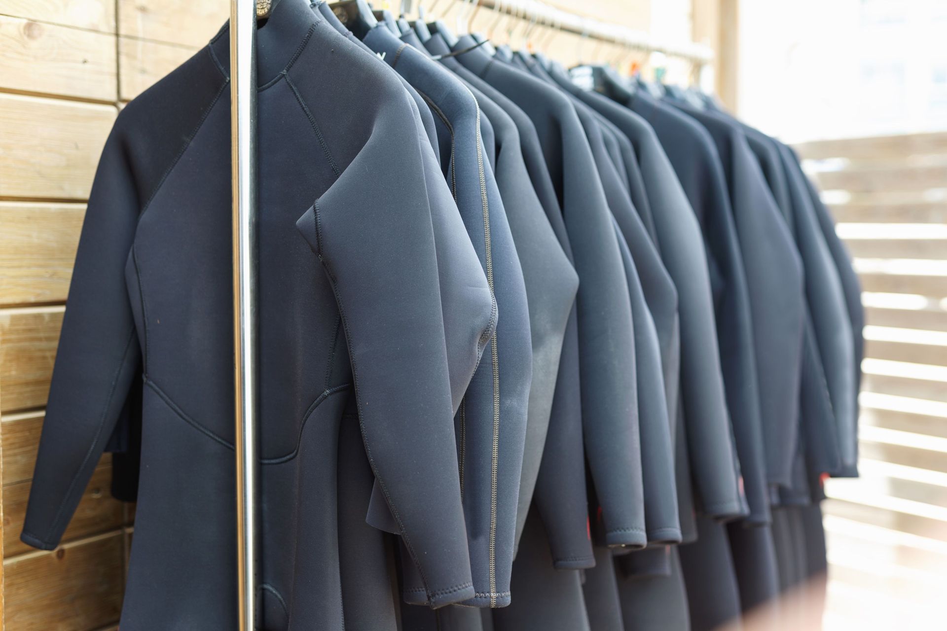 Wetsuits stored on rack