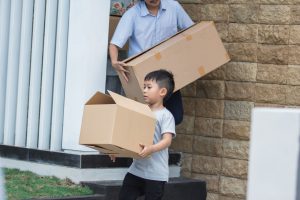 father and son moving house carrying boxes