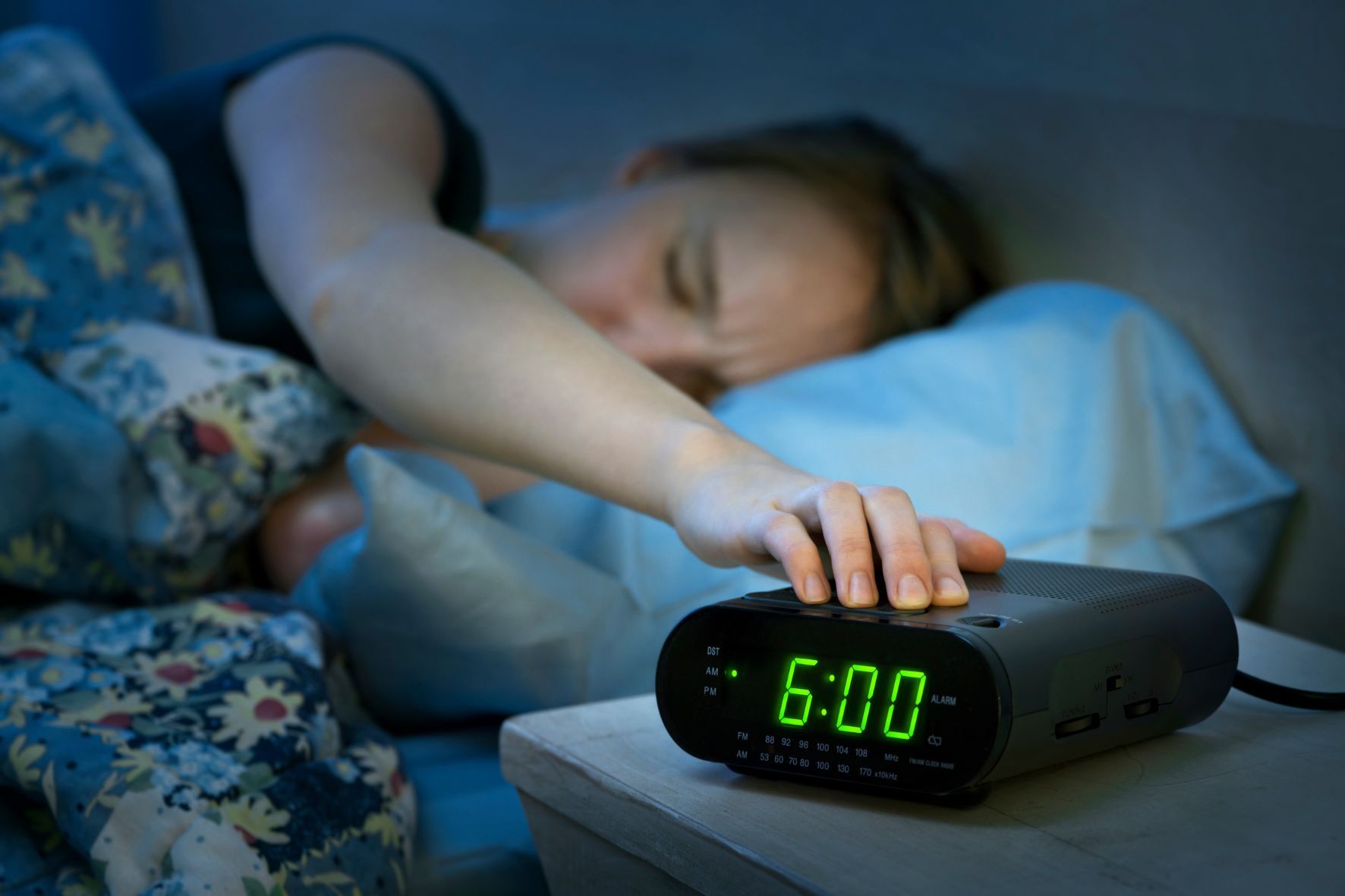 Person turning off alarm clock