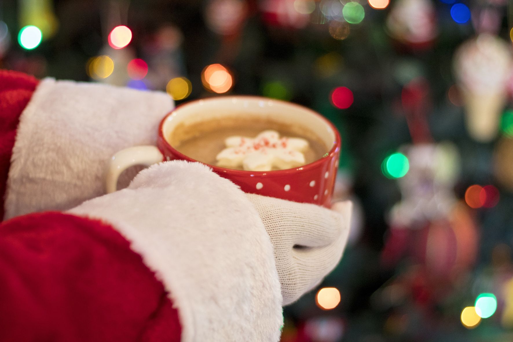 Santa holding cup of cocoa