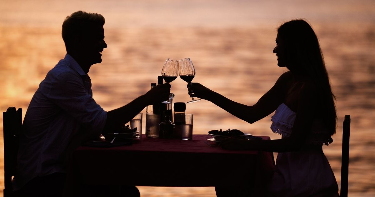 couple at dinner on the beach at sunset