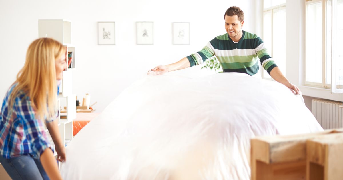 Couple covering furniture for home renovation